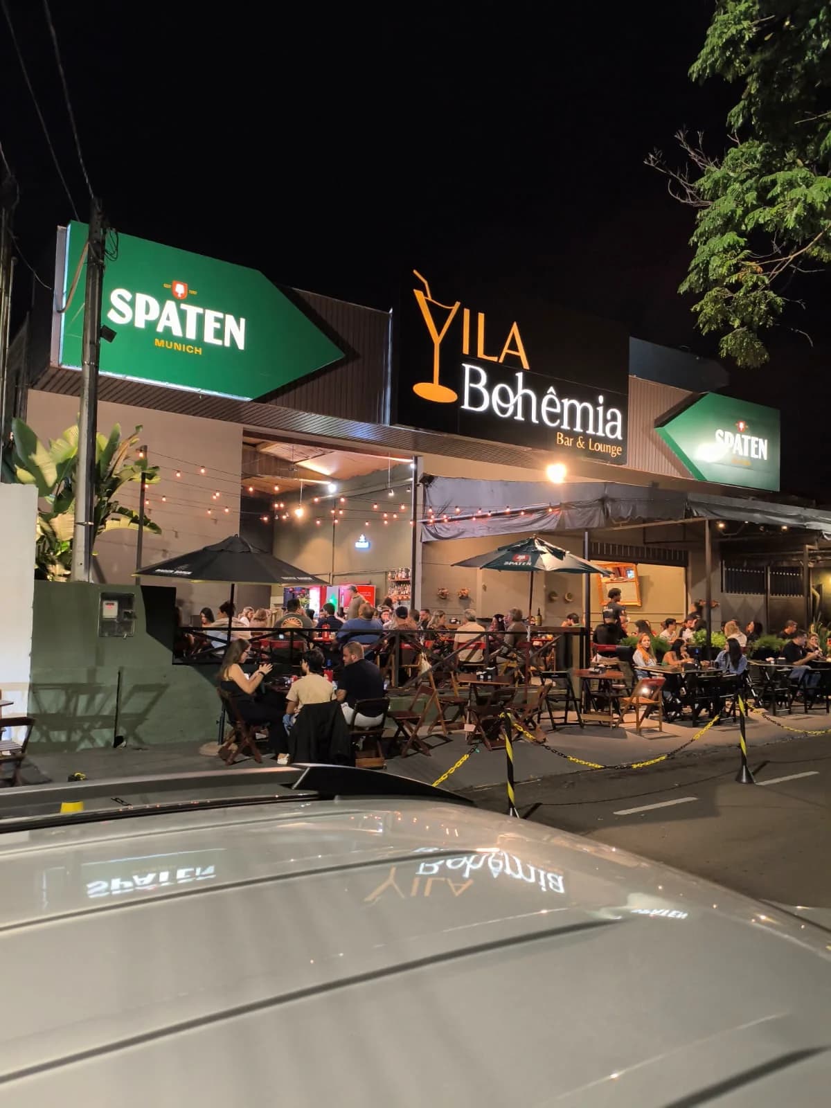 Fachada do Vila Bohêmia iluminada à noite